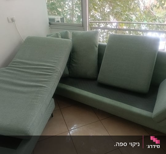 ספה ירוקה עם כריות על רצפה רטובה